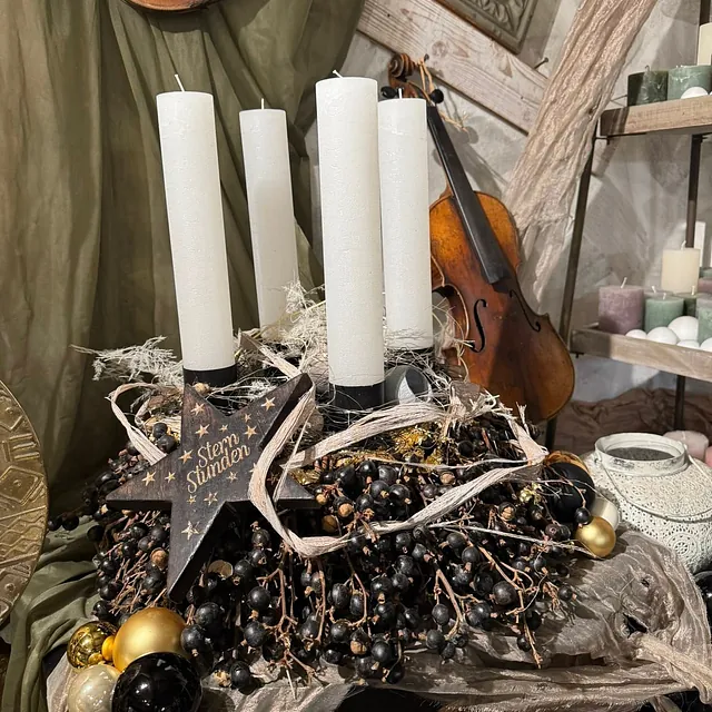 Adventskranz mit vier weißen Kerzen, schwarzen Beeren, goldenen Kugeln und einem Holzstern mit der Aufschrift 'Stern Stunden'