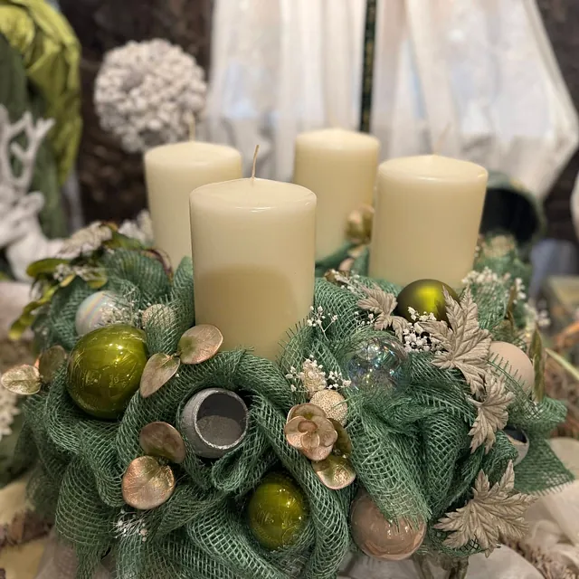 Adventskranz mit vier weißen Kerzen, grüner Juteband-Dekoration, goldfarbenen und grünen Kugeln sowie getrockneten Blättern